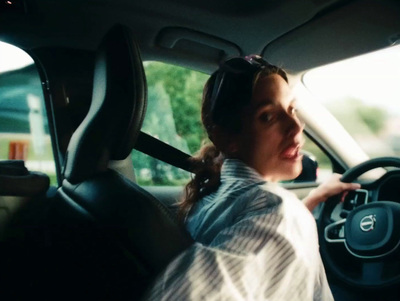 a woman driving a car with headphones on