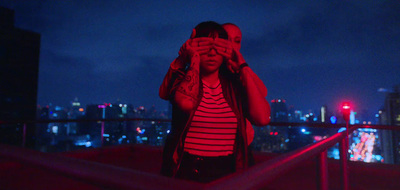 a woman covering her eyes while standing on top of a building