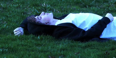 a person laying on the ground in the grass