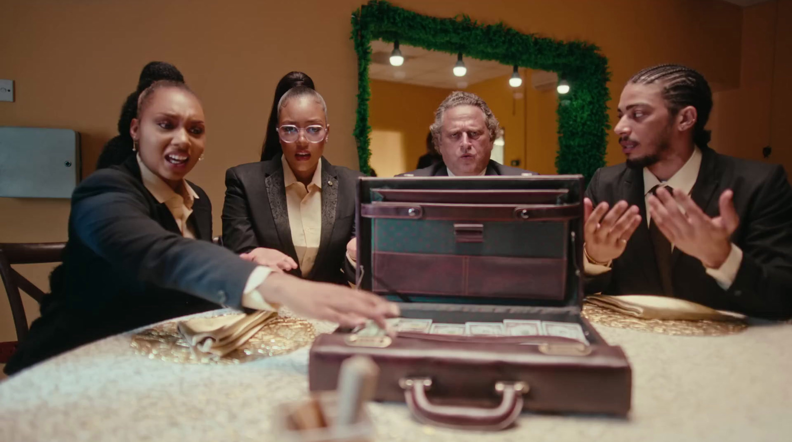 a group of people sitting around a table with a briefcase