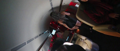 a woman in a black dress is walking down the stairs