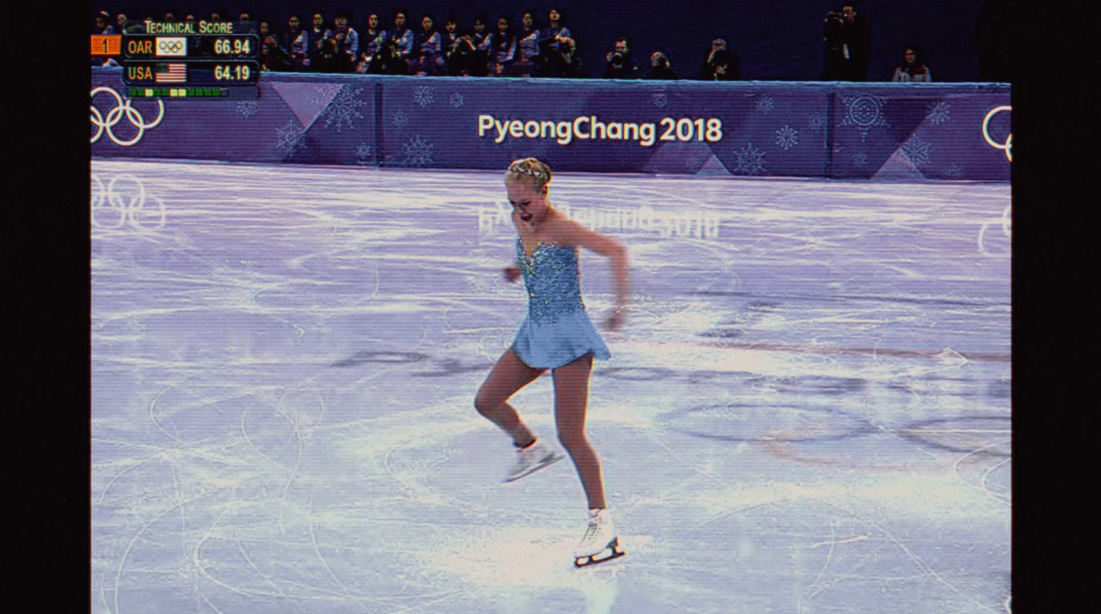 a female figure skating on an ice rink