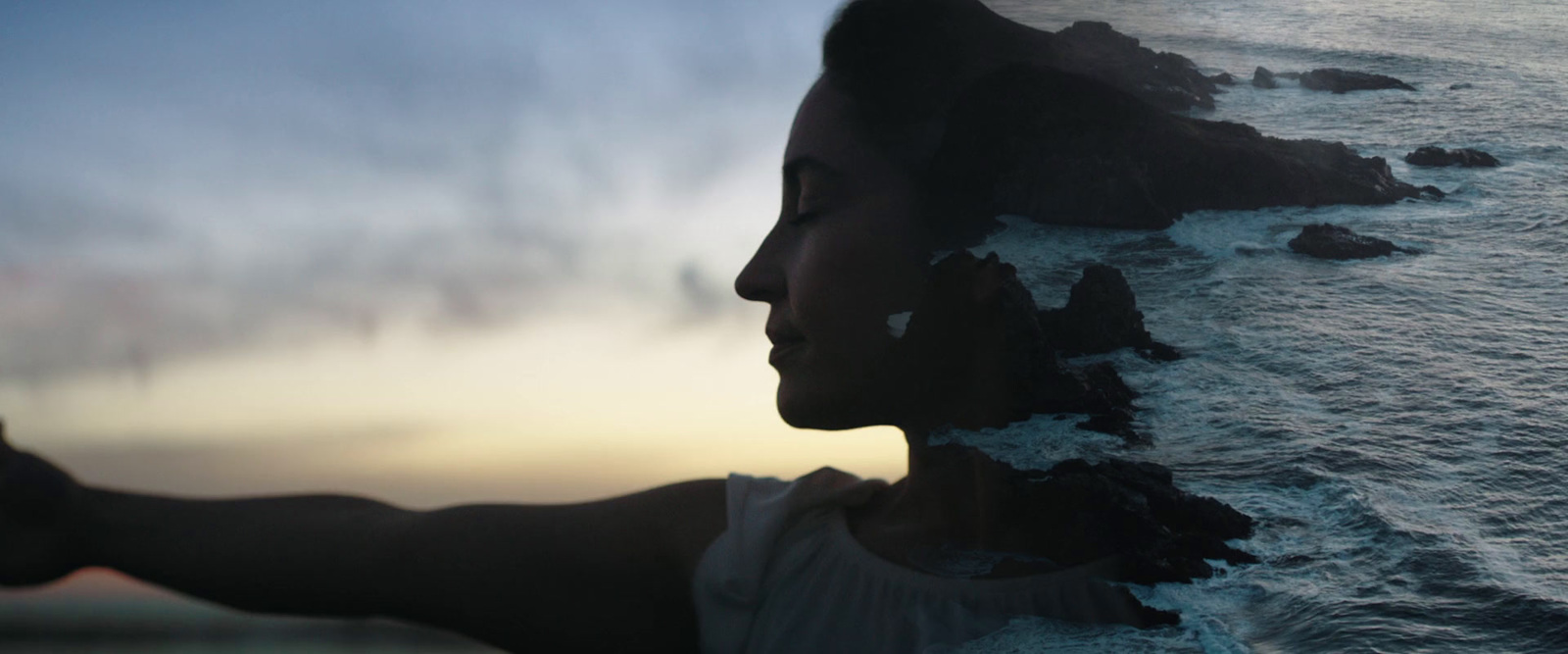 a woman standing next to a body of water