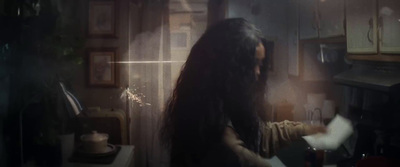 a woman with long hair standing in a kitchen