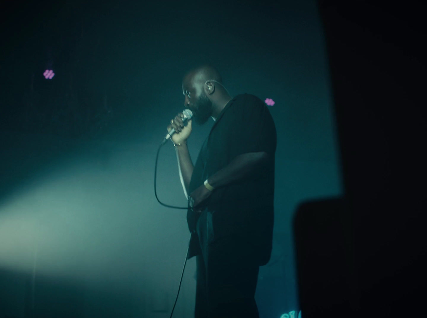 a man standing in front of a microphone on a stage