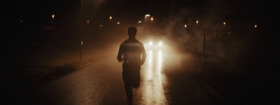 a man walking down a street at night