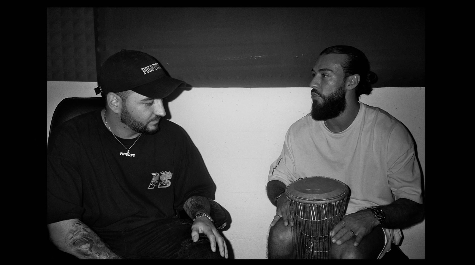 a black and white photo of two men sitting next to each other