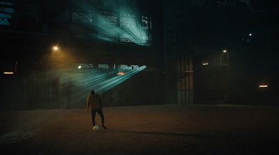 a person standing in a dark room with a soccer ball