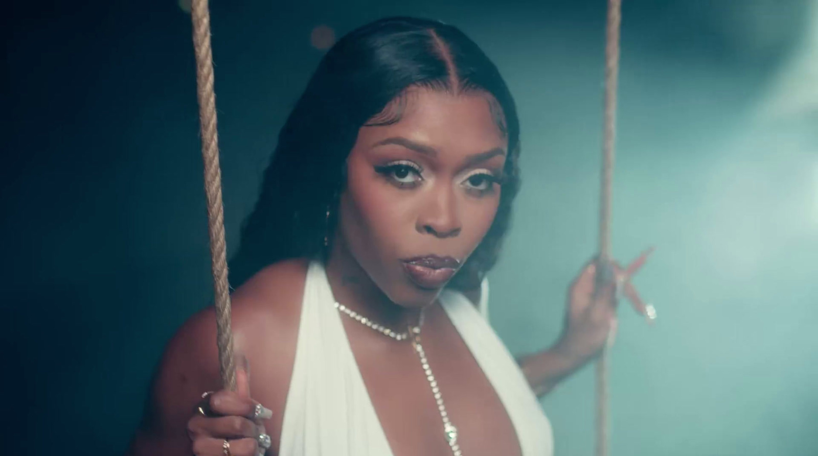 a woman in a white dress on a swing