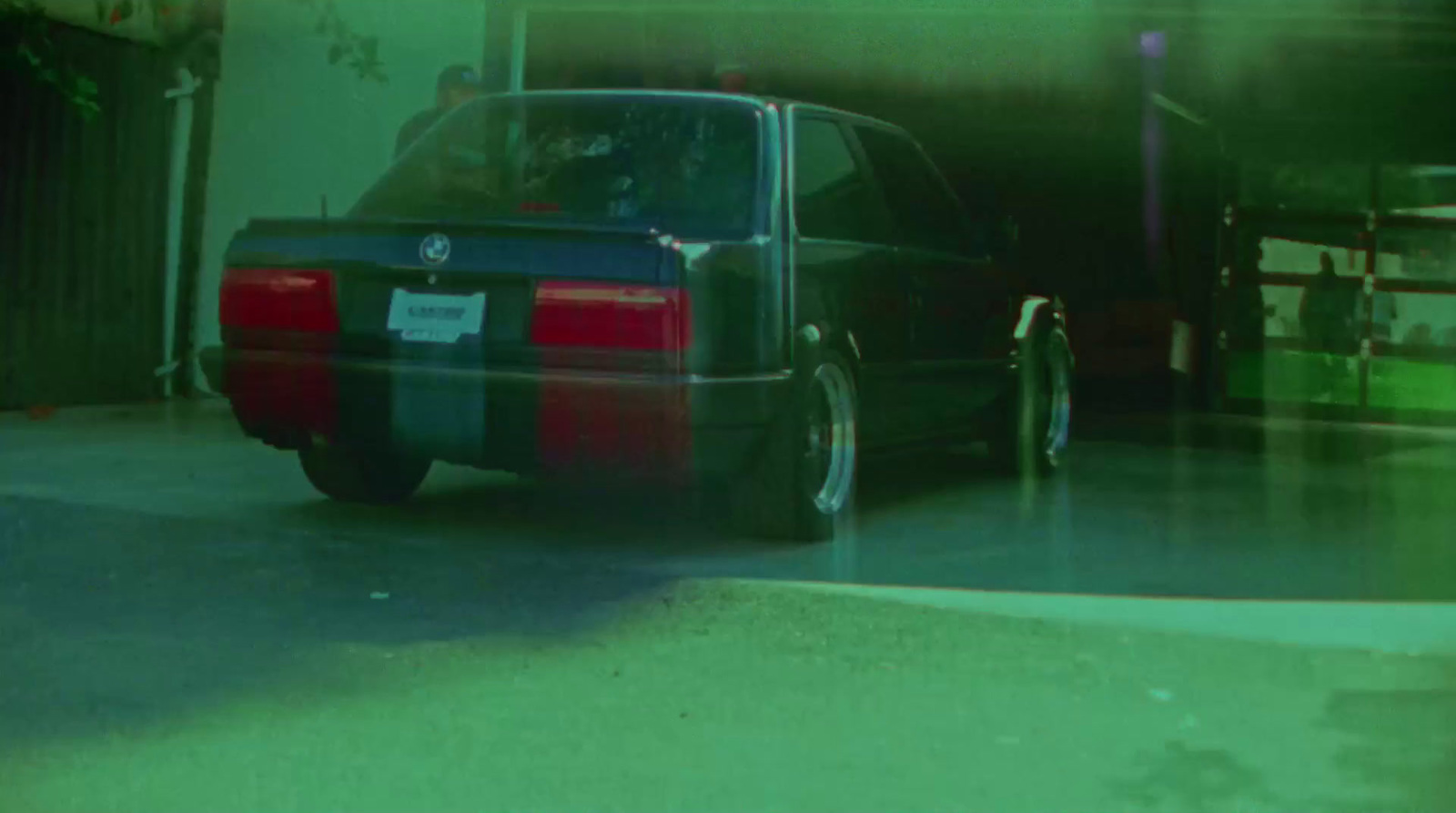 a car parked in a garage next to another car