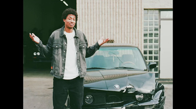 a man standing in front of a black car