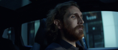 a man with a beard sitting in a car