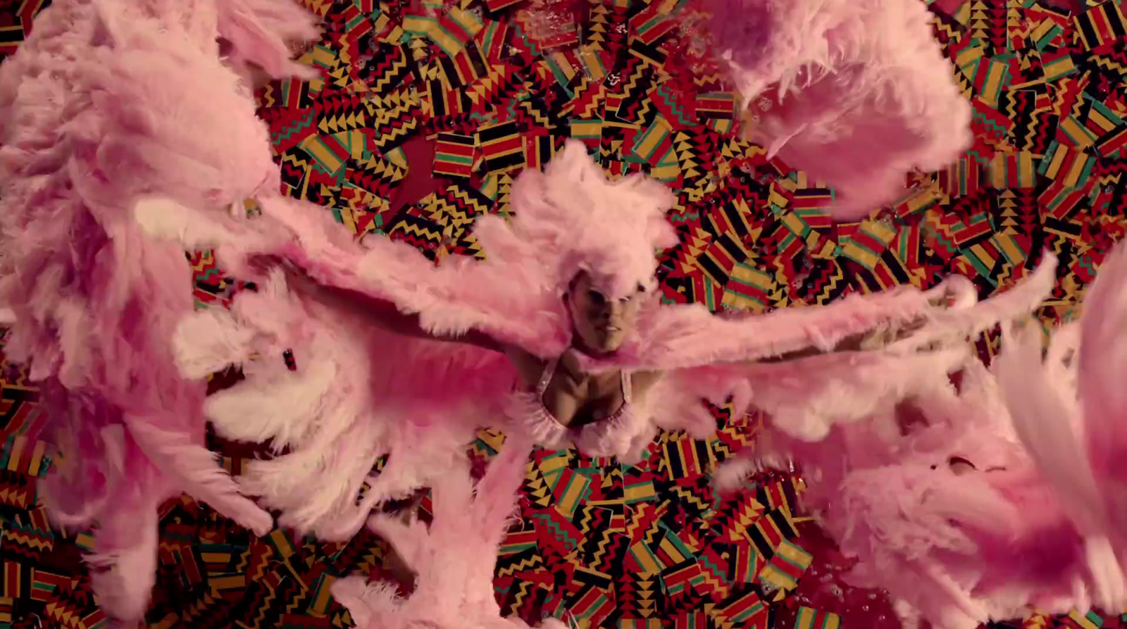 a group of pink feathers on a colorful surface