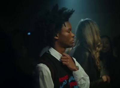 a man with dreadlocks standing in a dark room