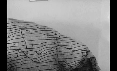 a black and white photo of a bed with a comforter