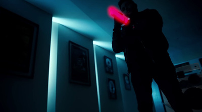 a man standing in a dark room holding a red object