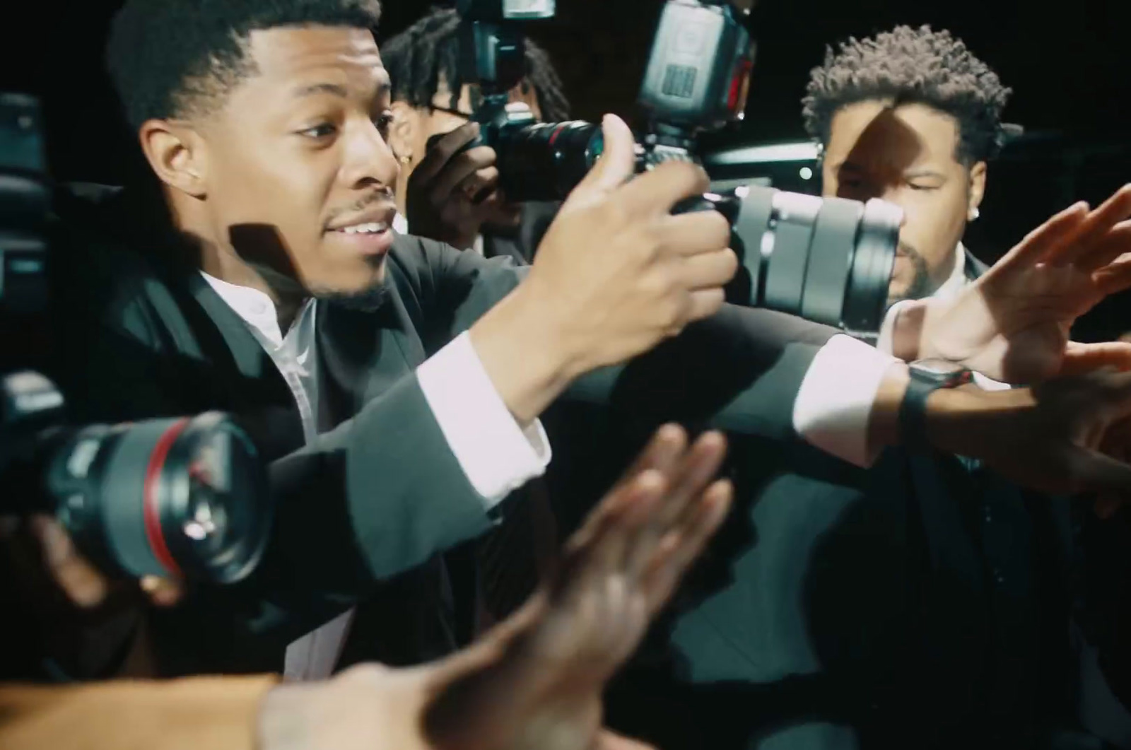 a man in a suit is surrounded by photographers