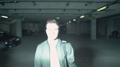 a man standing in a parking garage next to a car