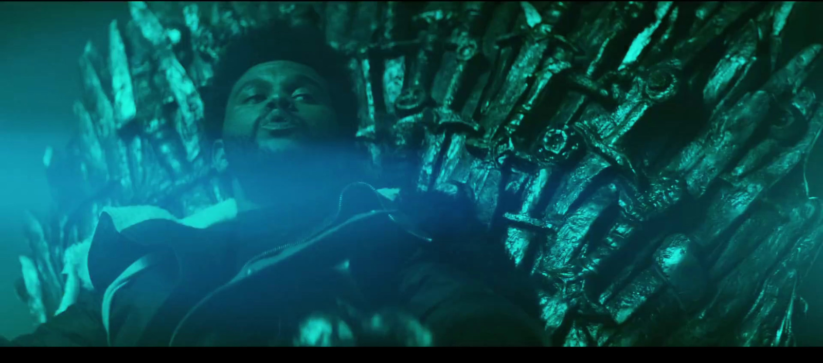 a man sitting on top of a giant iron throne