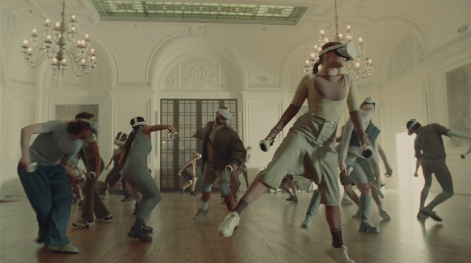 a group of people dancing in a room with chandeliers