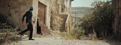 a man walking down a street next to a building