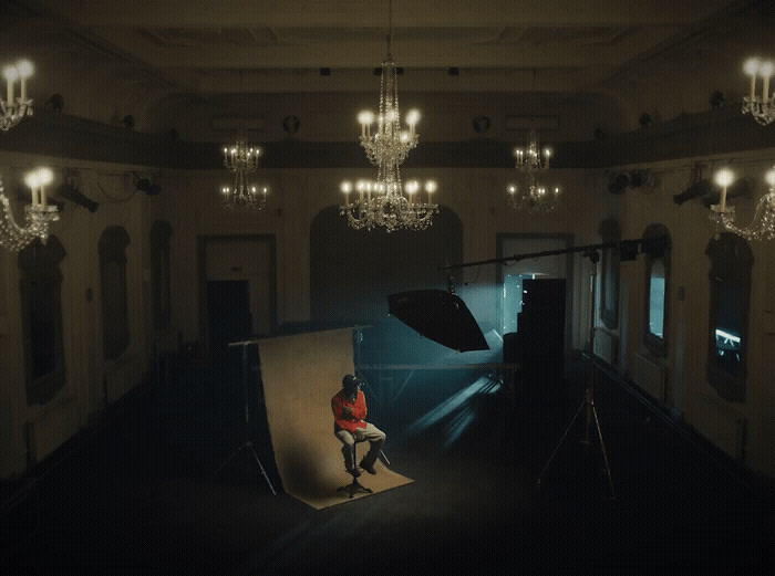 a person sitting on a chair in a room with chandeliers