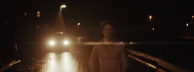 a man standing on a wet road at night