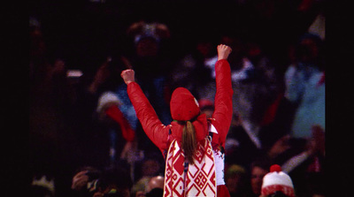 a woman in a red and white outfit holding her arms up in the air