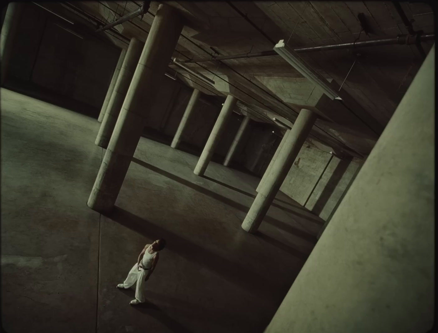 a woman standing in an empty building with columns