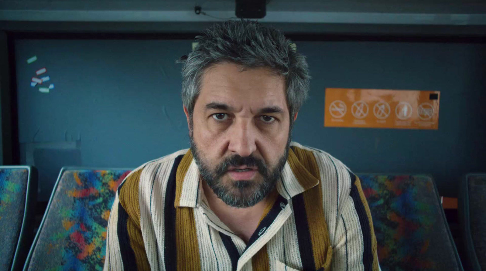 a man with grey hair and a beard sitting on a bus