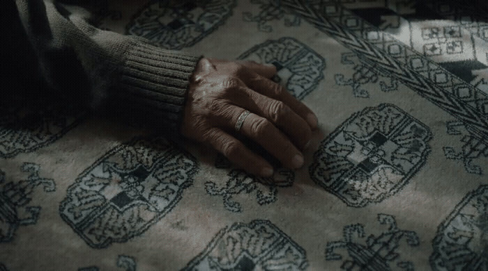 a person's hand resting on top of a rug