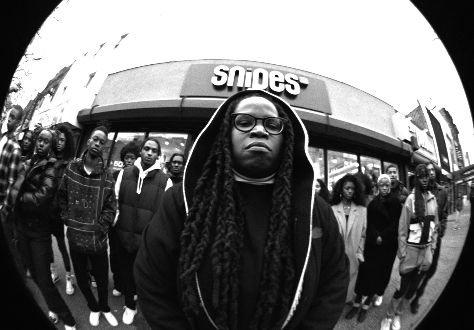 a man with dreadlocks standing in front of a store