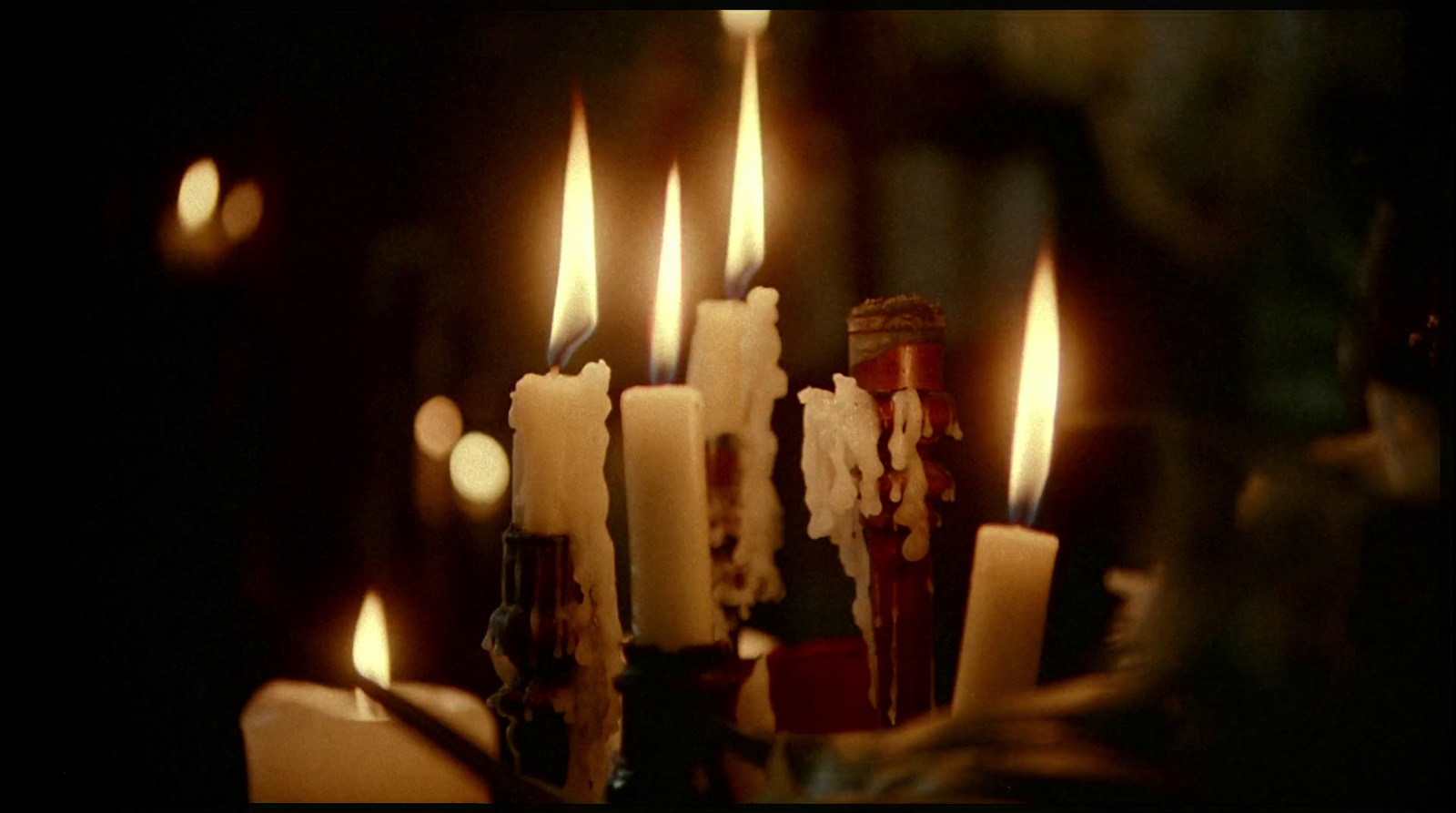 a group of lit candles sitting next to each other