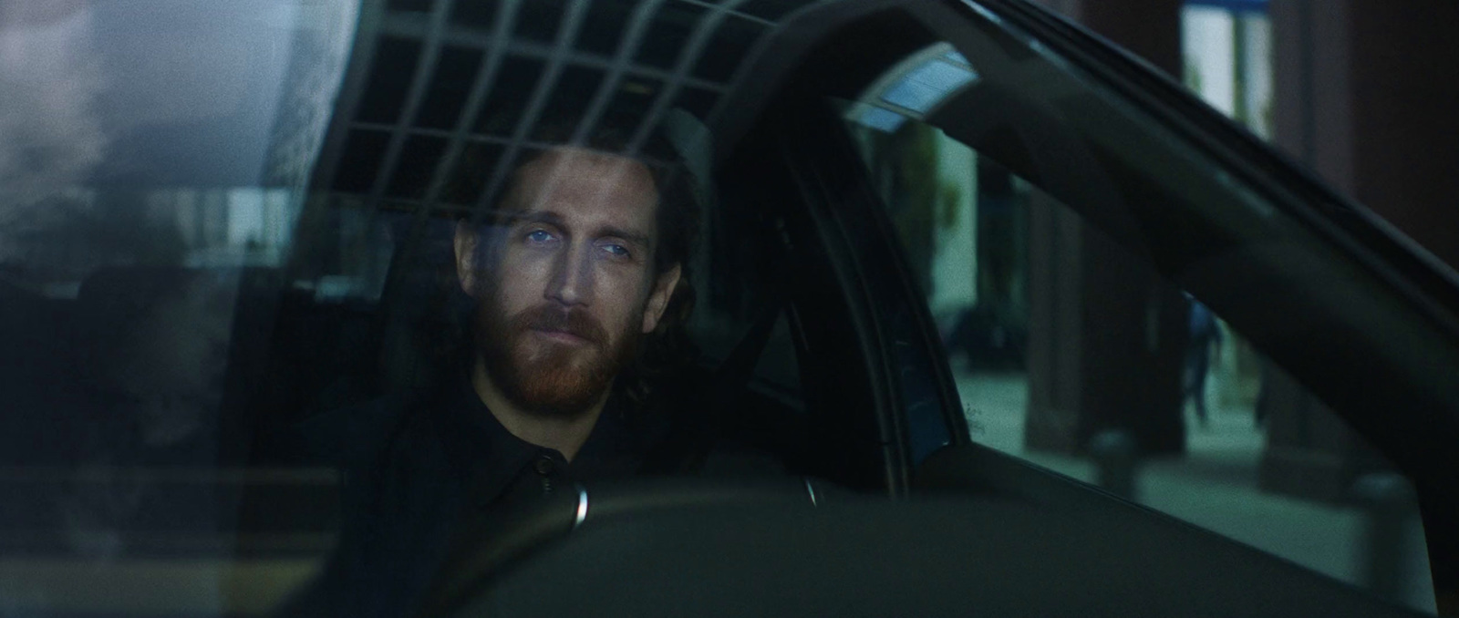 a man with a beard sitting in a car