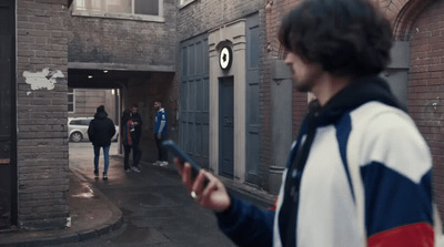 a man holding a cell phone in a narrow alley