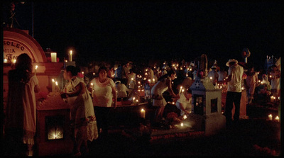 a group of people standing around a table with candles