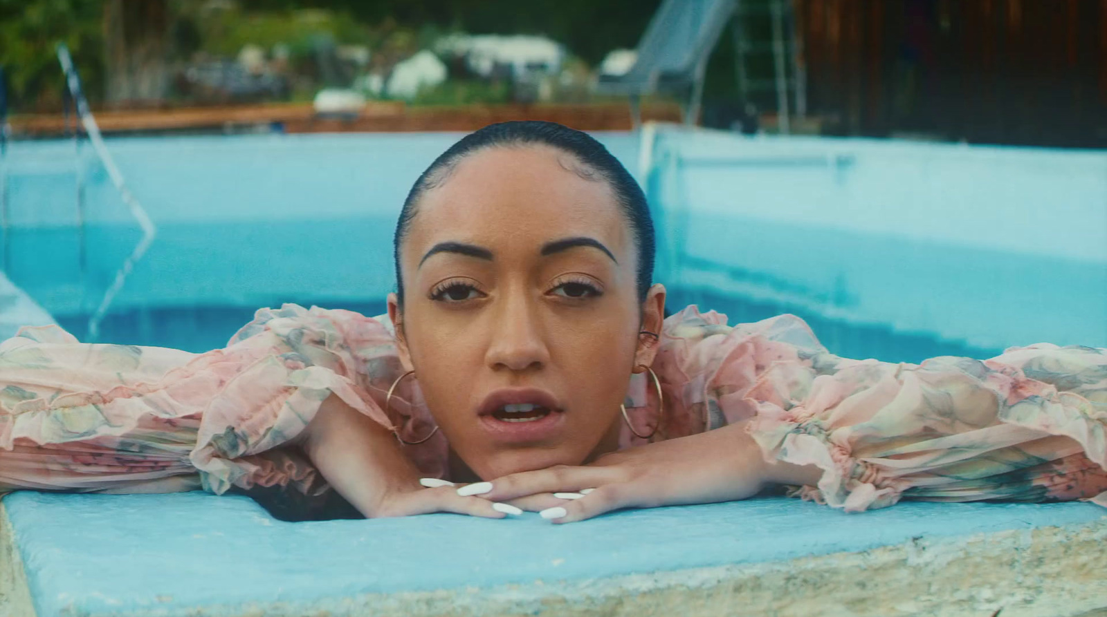 a woman laying in a pool with a surprised look on her face