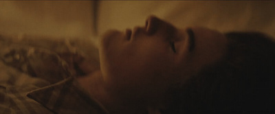 a woman laying in bed with her eyes closed