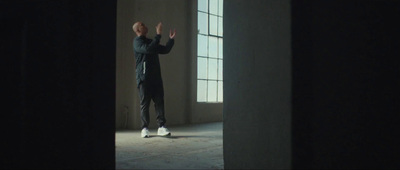 a man standing in a dark room with his hands in the air