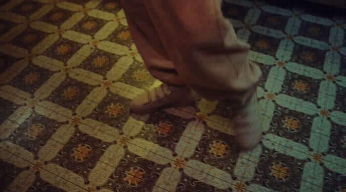 a person standing on a tiled floor in a room