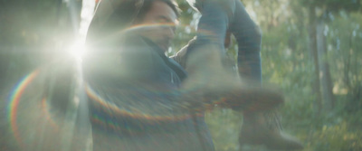 a blurry image of a woman standing in a forest