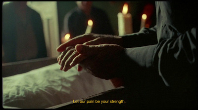 a person holding their hand over a bed with candles in the background