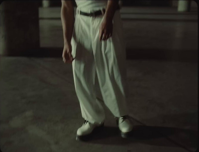 a man in white pants and a black belt