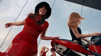 a woman in a red dress standing next to a red motorcycle