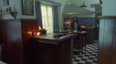 a woman standing in a kitchen next to a stove top oven