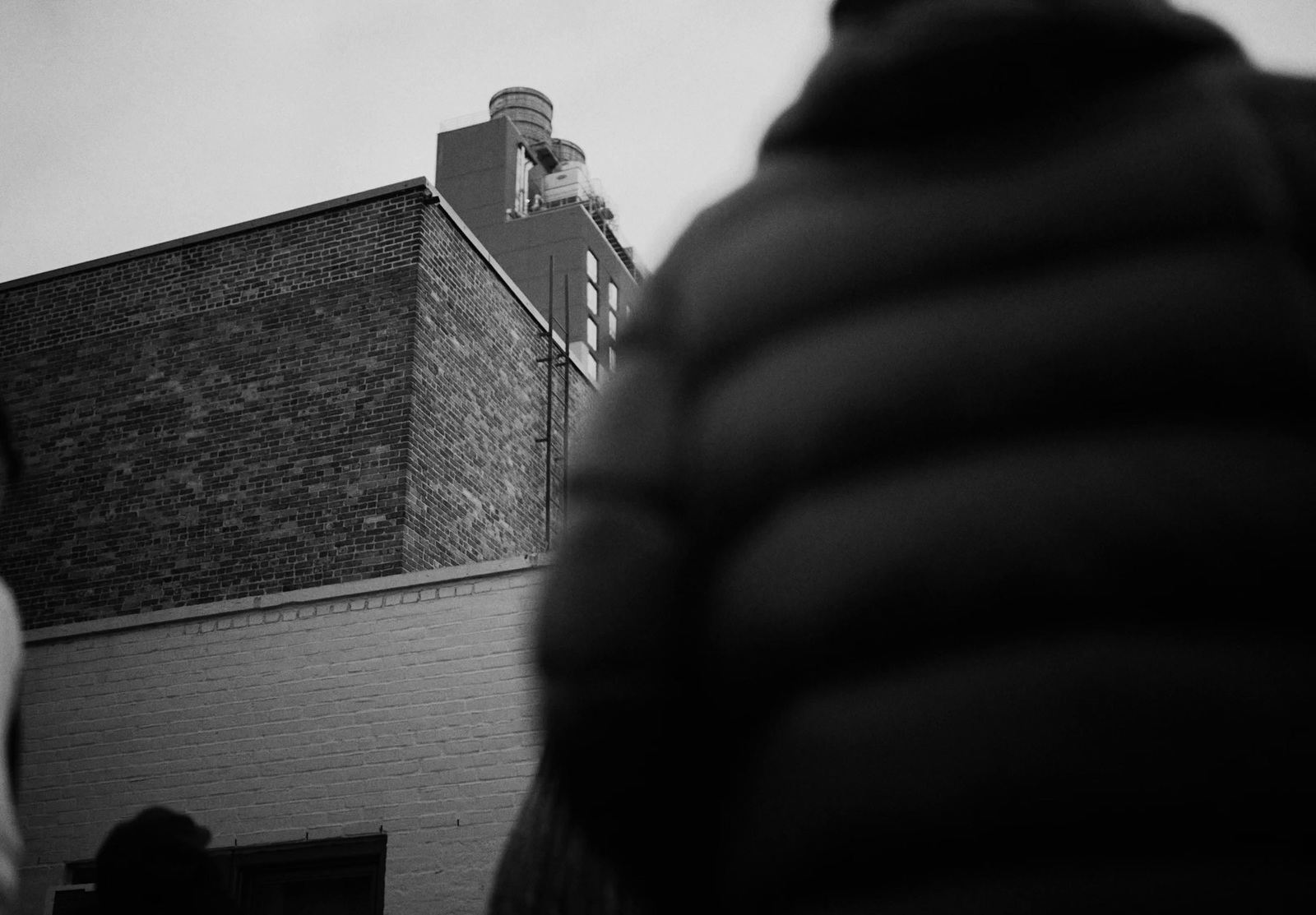 a black and white photo of a person standing in front of a building