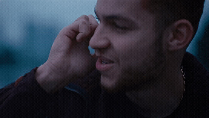 a man talking on a cell phone while wearing a black jacket