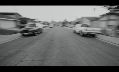 a black and white photo of cars driving down a street