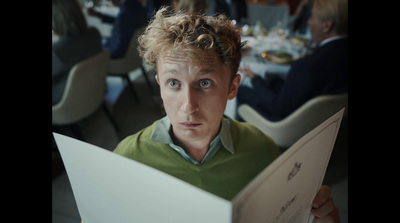 a man with curly hair holding a piece of paper