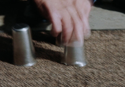 a person holding a pair of silver thimbles